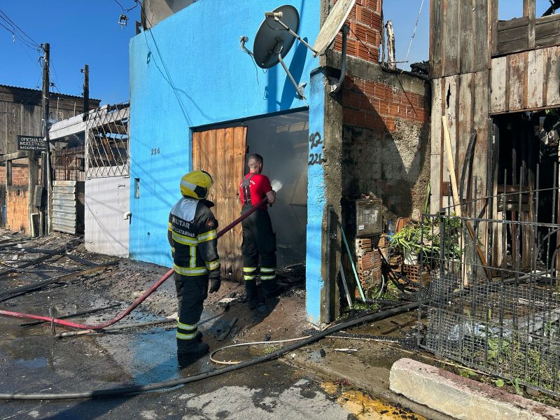 Foto mostra bombeiros combatendo incêndio em uma das casas