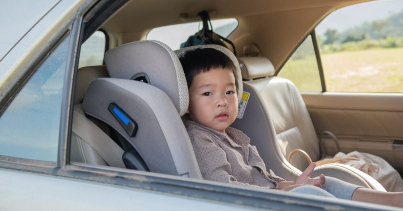 Criança dentro de carro sentada em cadeirinha infantil