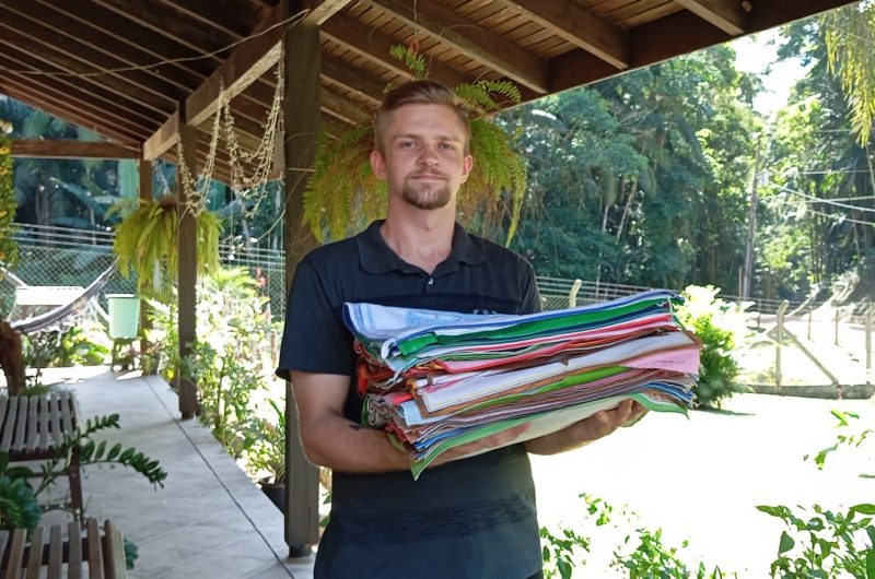 Ewerton segurando calendários que coleciona em Pomerode 