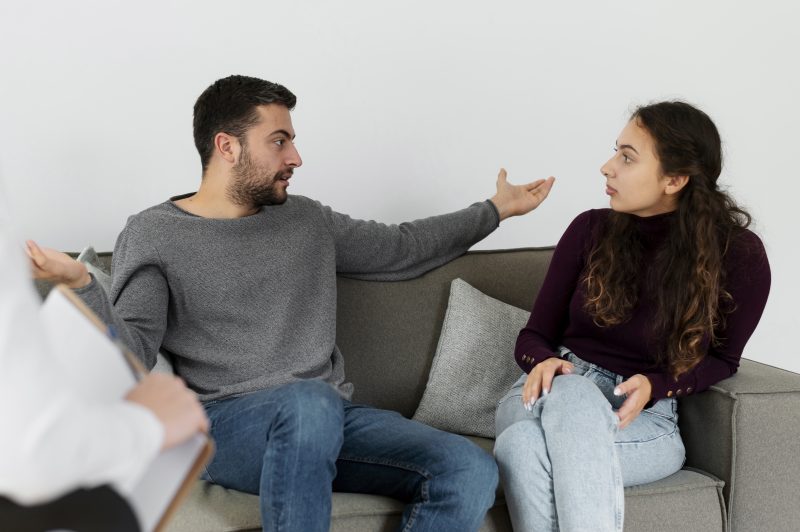 Homem e mulher conversando em sofá 