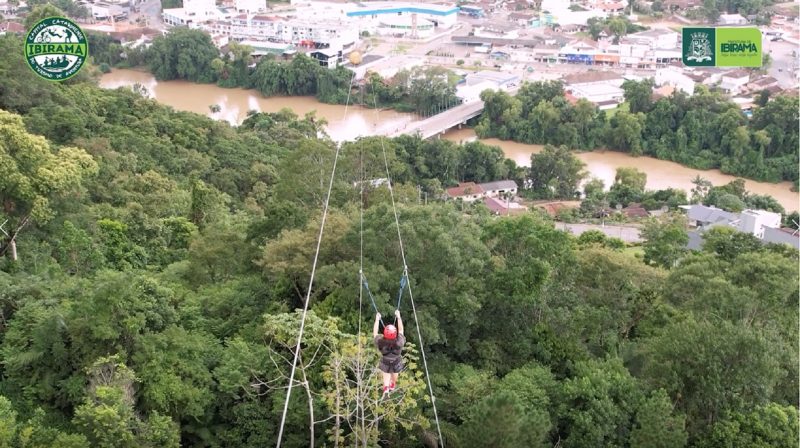 Mulher fazendo tirolesa durante atividade em Ibirama 