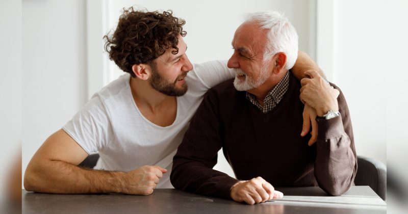 Dois homens, um de mais idade e o outro mais novo abraçados