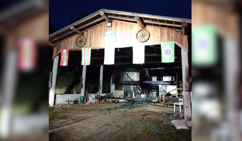 Incêndio em CTG matou quatro cavalos, foto mostra pavilhão carbonizado com bandeira penduradas no lado de fora