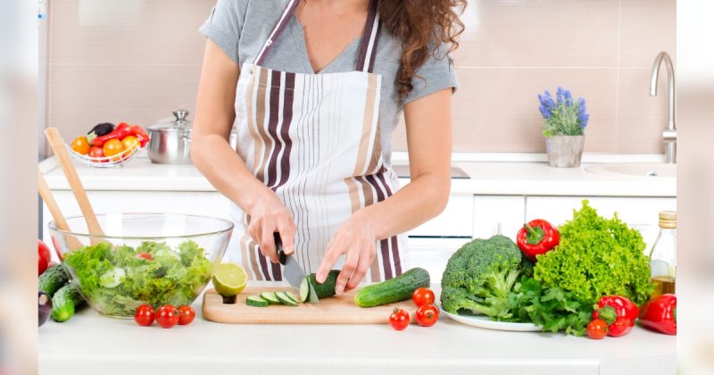 Pessoa cortando legumes e verduras 