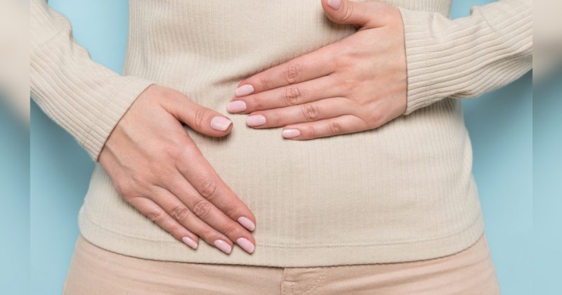 Mão feminina tocando em barriga