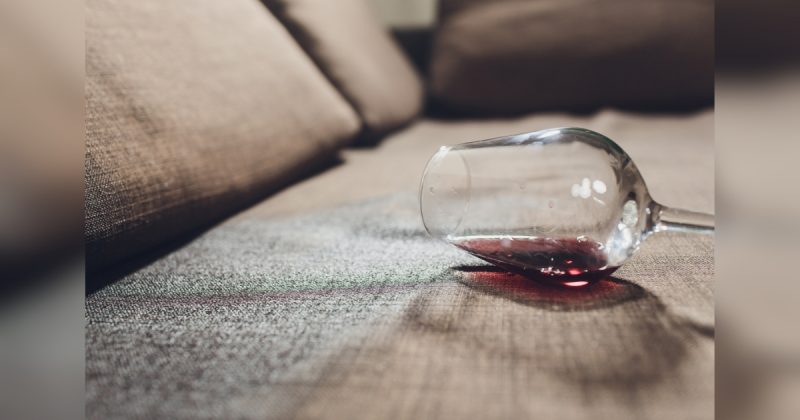 Copo caído no sofá com vinho