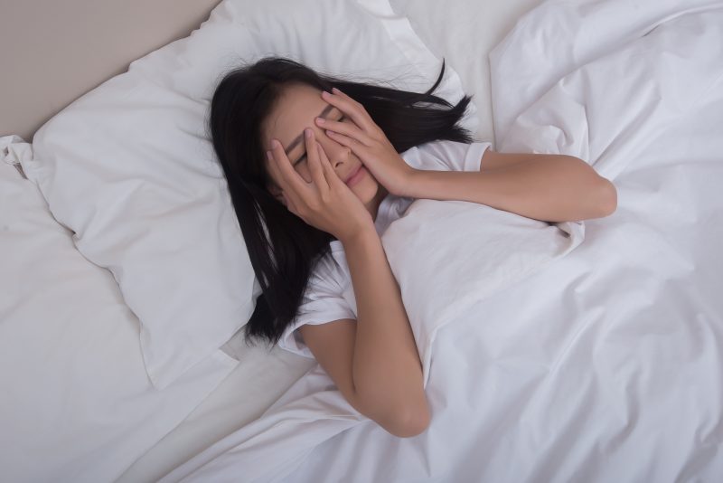 Mulher sofrendo com insônia em uma noite de lua cheia