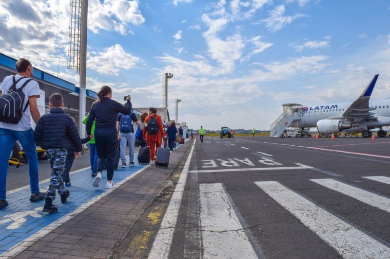 pessoas caminhando em direção ao avião no aeroporto de chapecó para voos para Florianópolis 