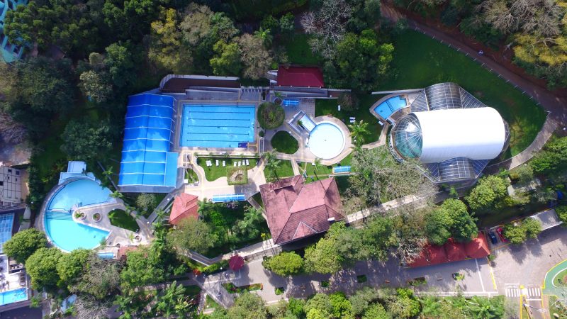 Vista aérea do complexo Termas de Piratuba. Na foto, aparecem quatro piscinas descobertas de diferentes tamanhos. Há também estruturas cobertas com piscinas, mas que não aparecem na imagem. O complexo é todo cercado por ávores. 