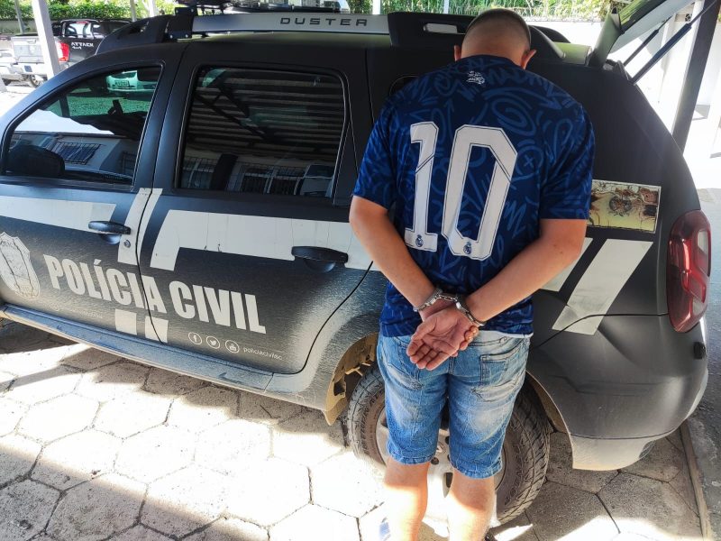 Suspeito de ameaçar expor fotos íntimas de adolescentes algemado em frente a carro da Polícia Civil 