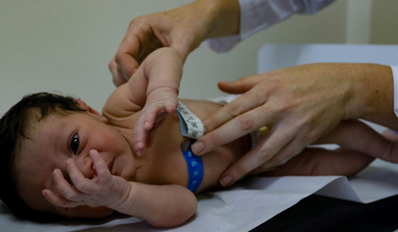 Criança sendo medida com fita métrica por médica