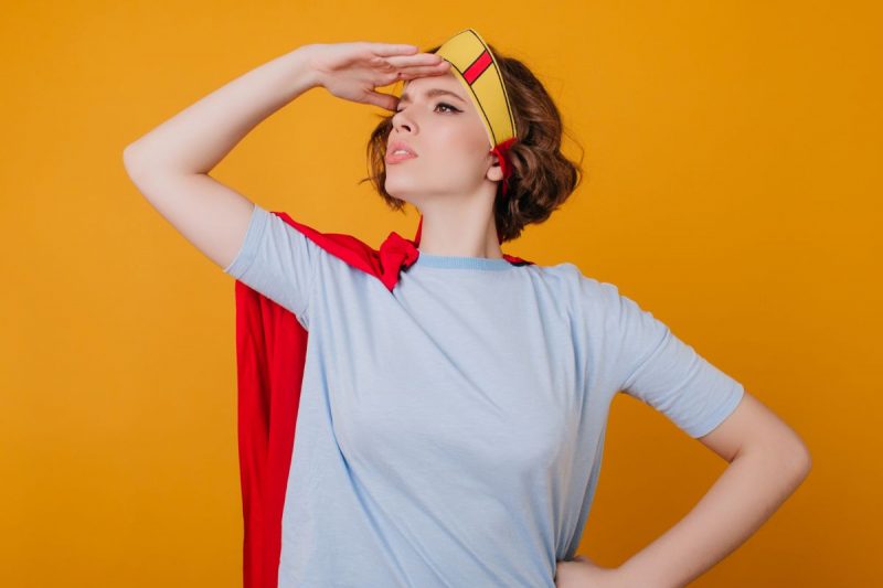 mulher de capa igual uma heroína olhando para o além