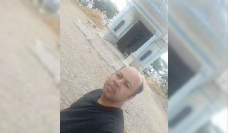 Albino fez selfie em frente a um cemitério