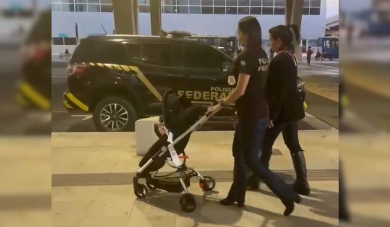 Bebê brasileiro vítima de tráfico humano foi repatriado na segunda-feira. Na imagem, agentes da PF levam o bebê em um carrinho.