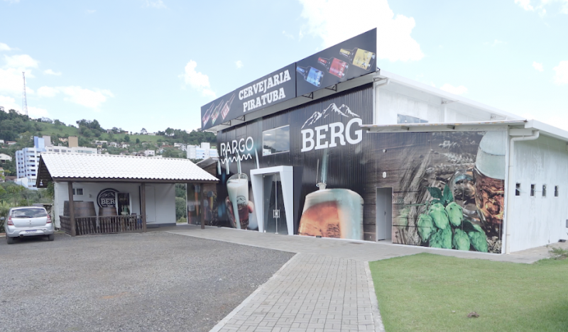 Foto lateral da fachada da Cervejaria Berg, com o nome dela e fotos de copos de cerveja, lúpulo.