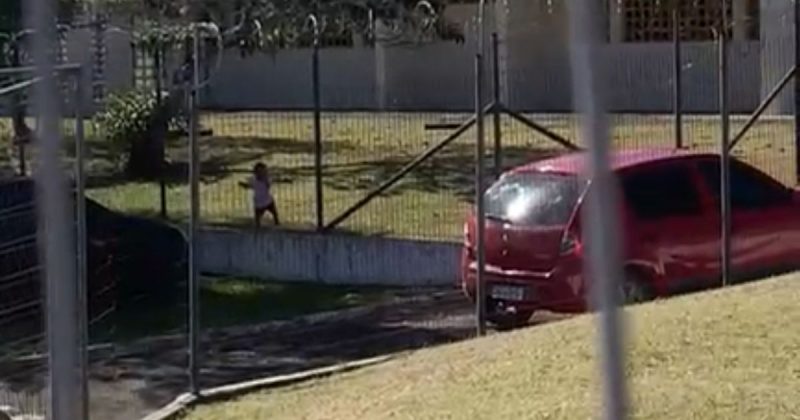 Criança sozinha na grade de creche em Criciúma