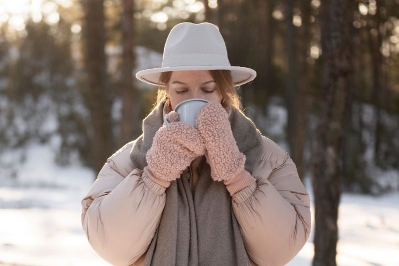 mulher tomando bebida quente em um inverno