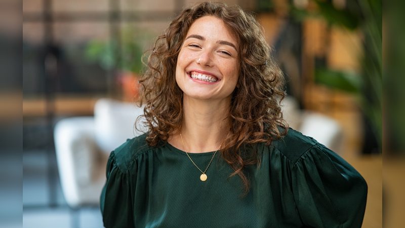 Mulher sorrindo de blusa verde