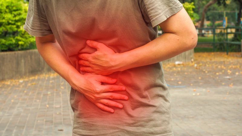 Pessoa com mãos na barriga em parte vermelha