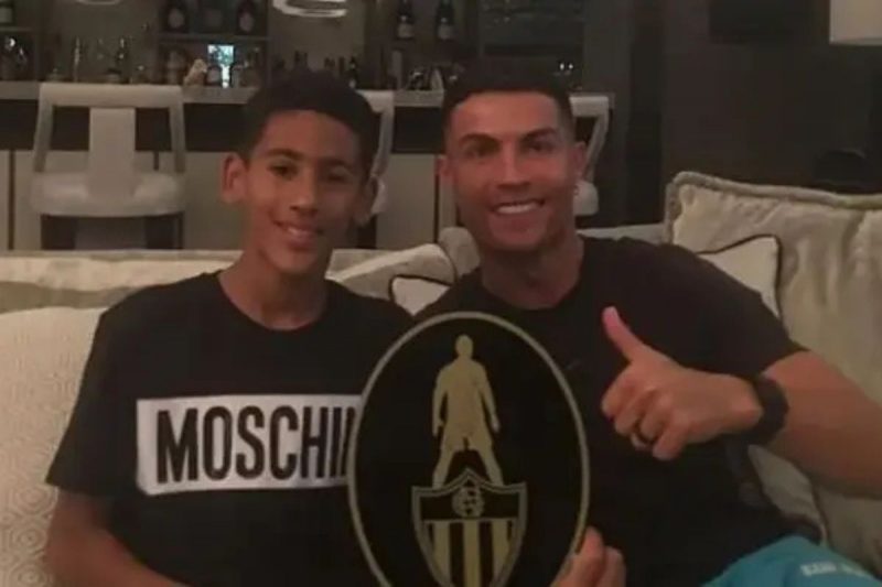 Kid Messi e Cristiano Ronaldo posando para foto no sofá
