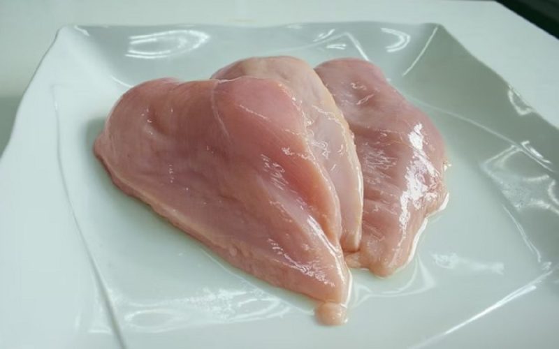 na foto aparece um peito de frango que gera mais proteína para os músculos pronto a ser preparado