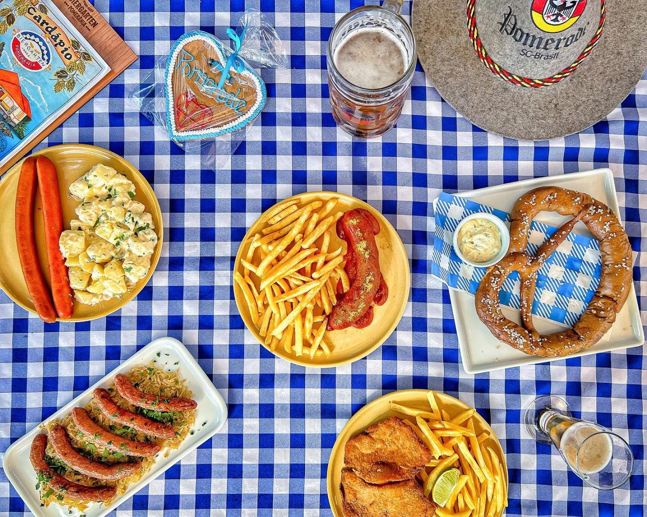 Mesa com vários pratos tradicionais da culinária alemã, como salsichas e bretzel - Biergarten Pomerania/Redes Sociais