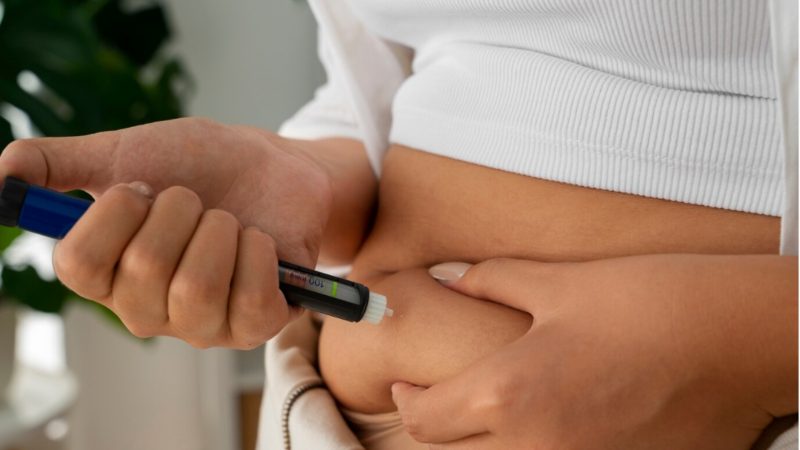 Pessoa apertando barriga para colocar agulha