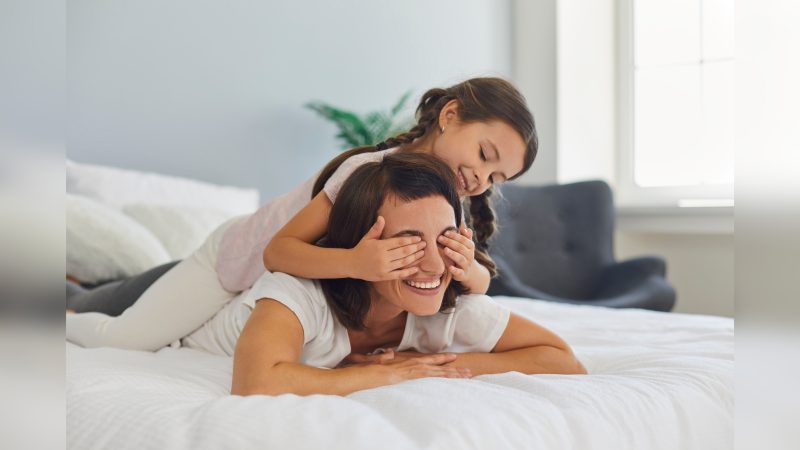 Criança tampando os olhos de mulher e sorrindo