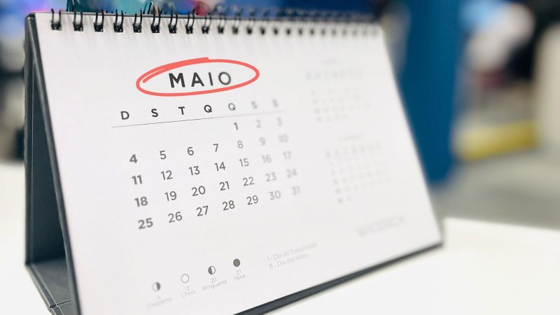 Maio tem apenas um feriado Imagem de um calendário do mês de maio de 2025 parcialmente desfocado para ilustrar a matéria de quem pode emendar o feriado 1º de maio.