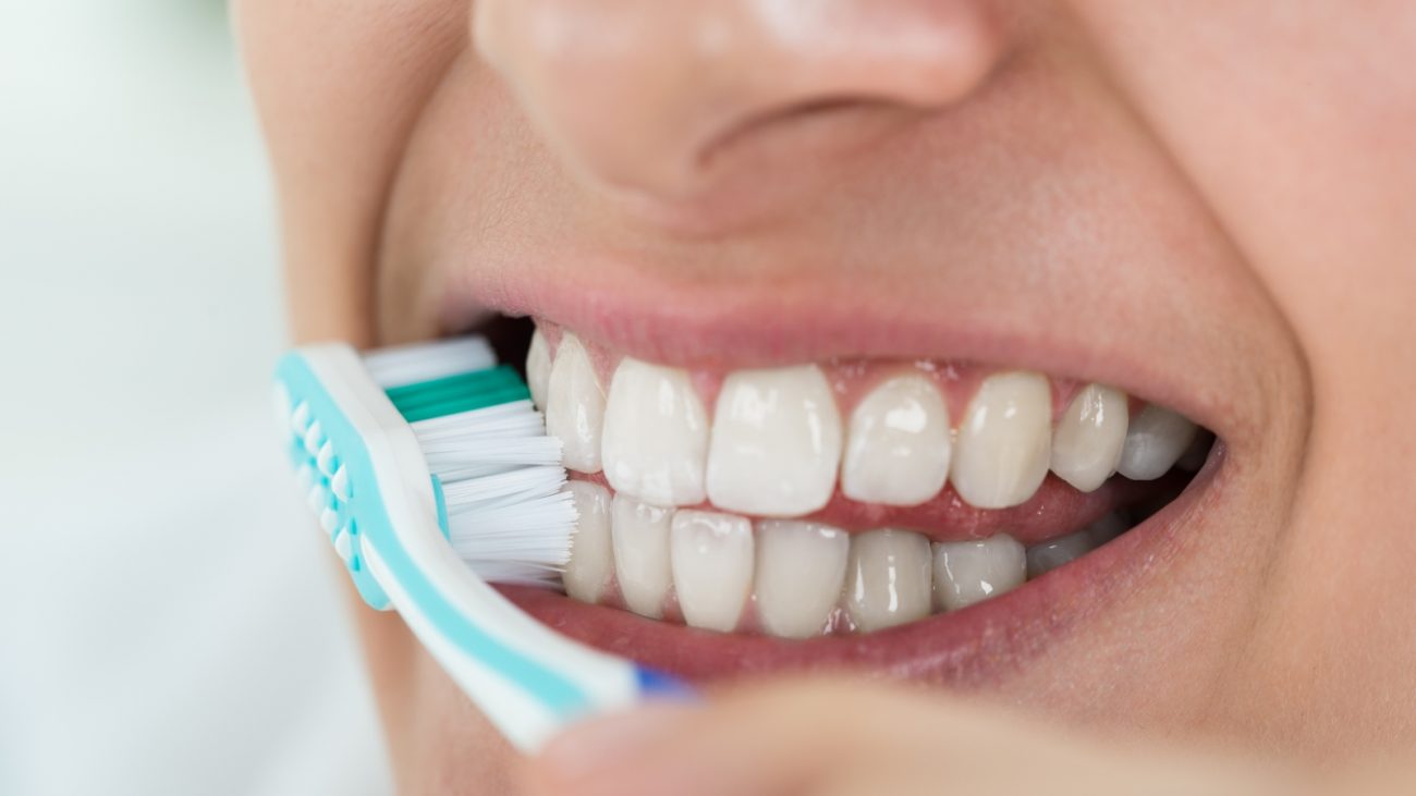 Pessoa escovando os dentes