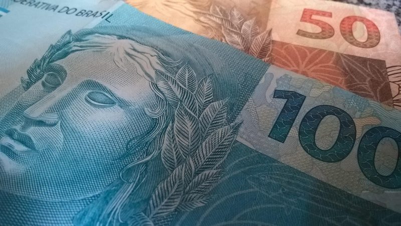 Dinheiro Notas de 100 e 50 reais. Imagem ilustra matéria "Reforma tributária o que muda para consumidores, empresas e governos?"
