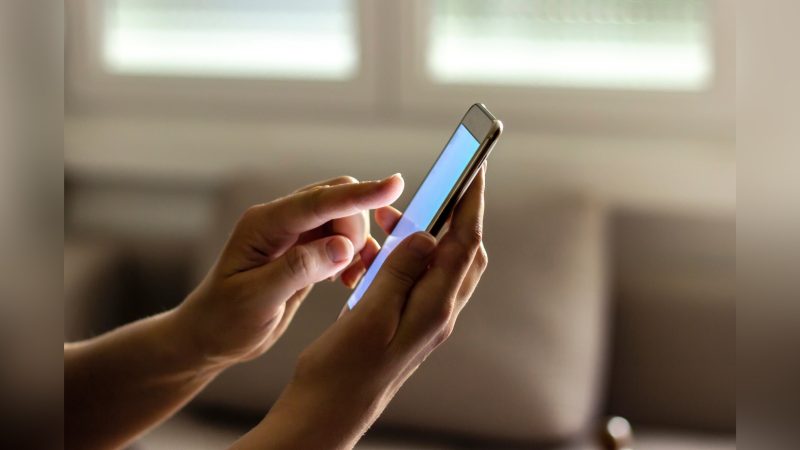 Pessoa segurando celular com mãos Pessoa segurando celular com mãos