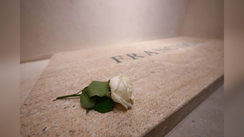 Imagem do túmulo do Papa Francisco com seu nome escrito e uma rosa branca