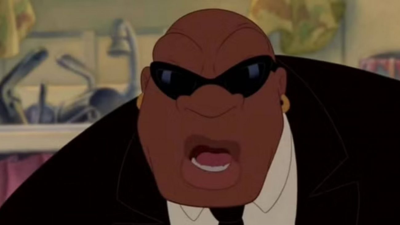 Agente Cobra Bubbles Imagem mostra cena do filme Lilo & Stitch onde aparece o personagem Agente Cobra Bubbles, um homem grande, de terno, brincos dourados e óculos escuros.