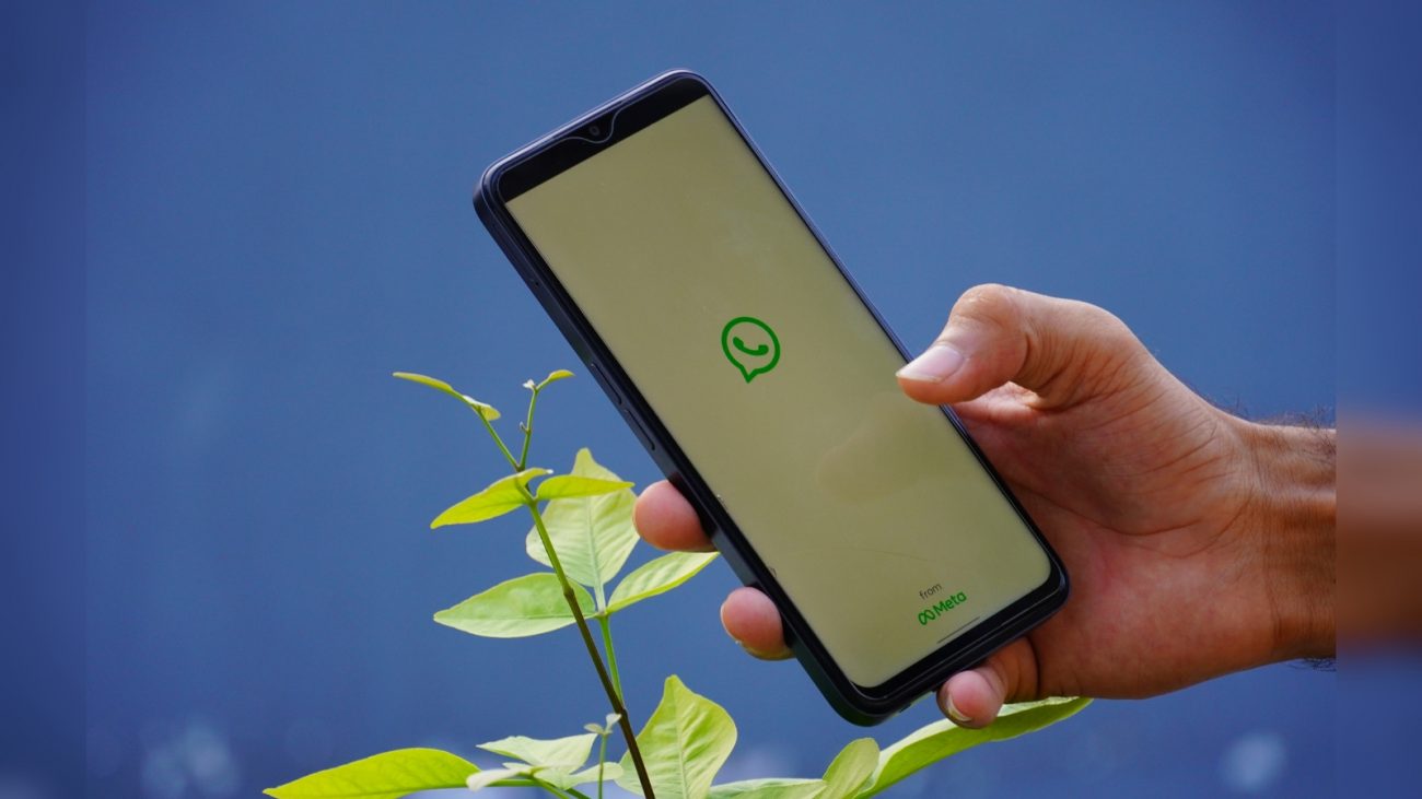 Pessoa com celular aberto no WhatsApp na mão
