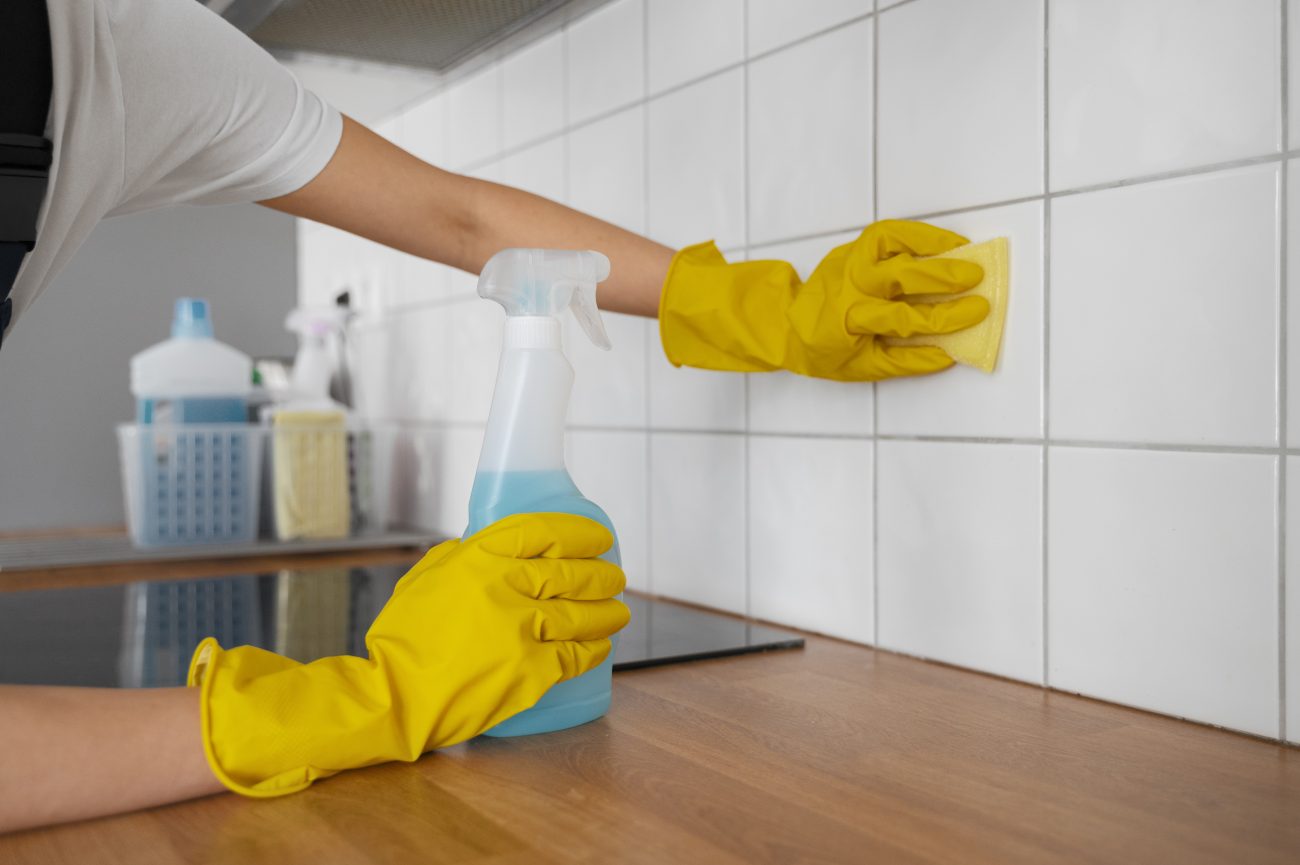Azulejos próximos ao fogão Pessoa limpando os azulejos próximos ao fogão