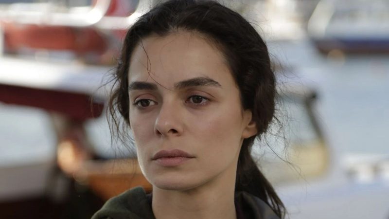 Personagem Bahar em "Força de Mulher" Imagem mostra a personagem Bahar da novela turca "Força de Mulher". A personagem aparece com a cara séria em um fundo desfocado.
