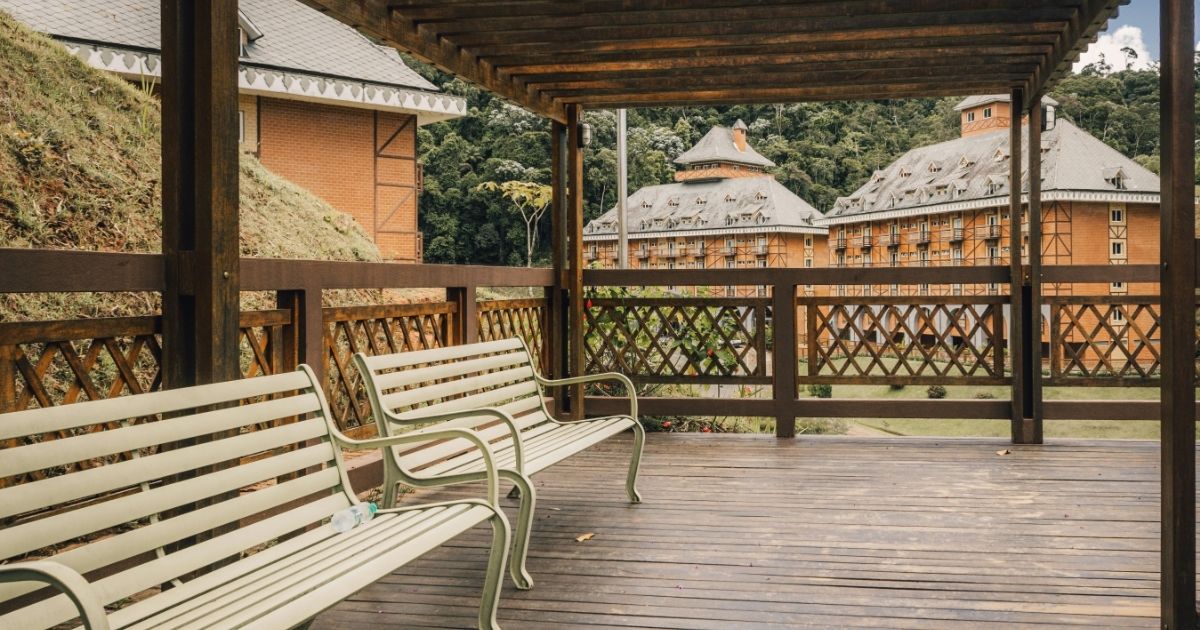 Imagem de uma varanda com bancos de madeira, para ilustrar mo ficaria esse objeto de decoração no espaço do leitor 