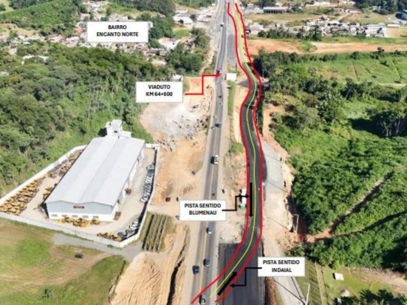 Imagem mostra rodovia BR-470 e sua obra complexa. Na imagem é possível ver o pavimento, muitas árvores ao redor e casas no fundo da foto. Desvio provisório na BR-470 altera trânsito por seis meses em Indaial