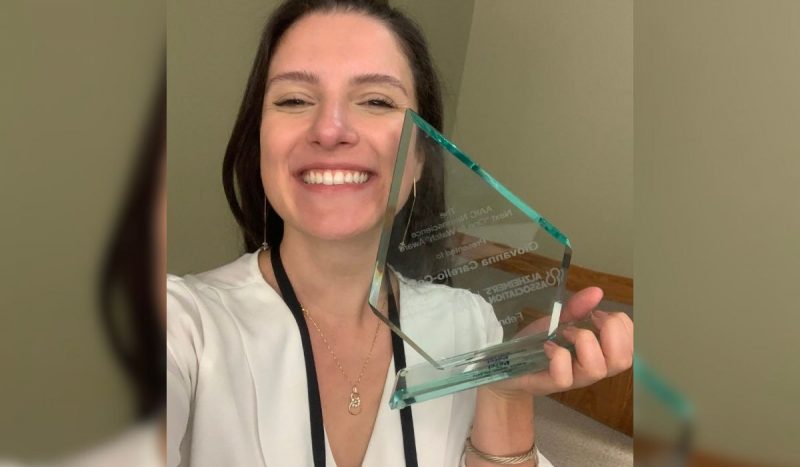 Brasileira vai para Harvard após estudo sobre Alzheimer Brasileira vai para Harvard após estudo sobre Alzheimer, foto mostra mulher branca, com cabelos castanhos, lisos e longos, sorrindo para foto enquanto segura próximo ao rosto um prêmio feito de vidro