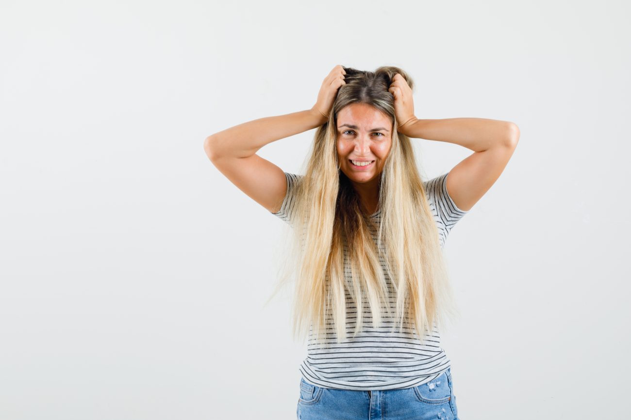 Mulher loira estressada com o cabelo oleoso 