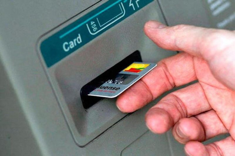 Cartão Homem com o cartão preso no caixa eletrônico