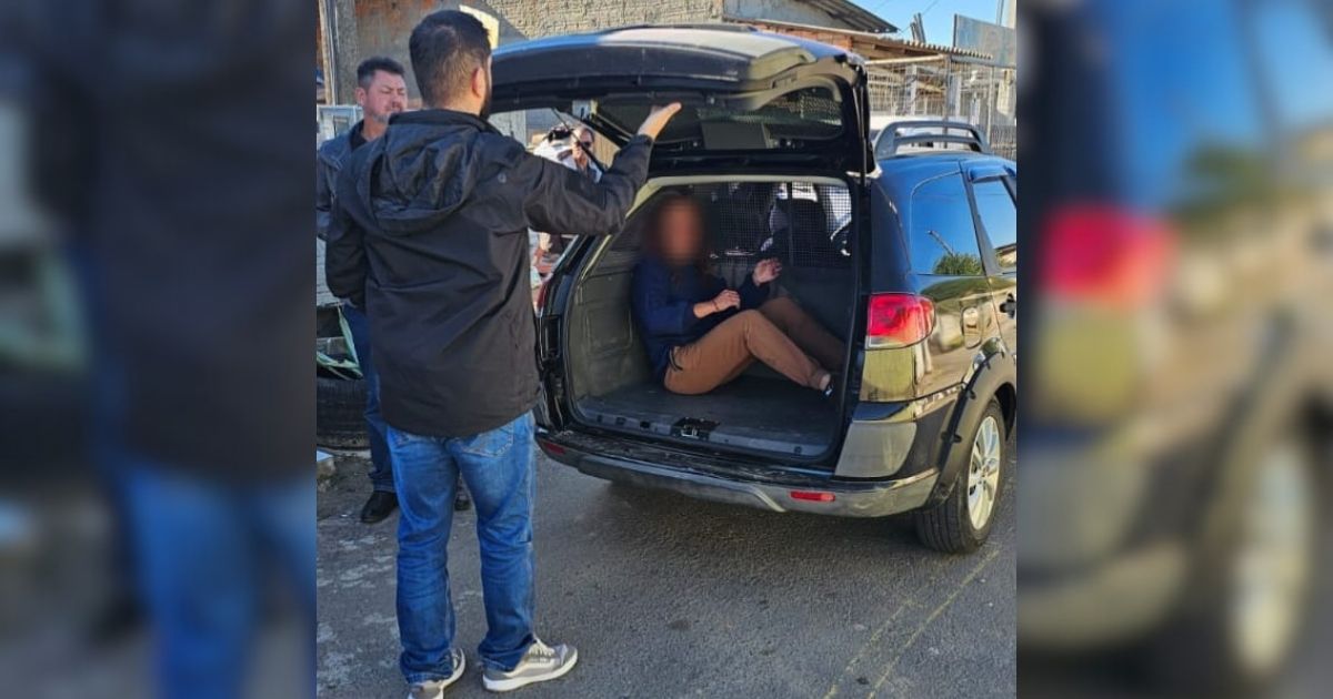 Imagem de uma mulher na viatura da polícia, para fazer referência aio fato de que o casal foi preso e encaminhado ao presídio 