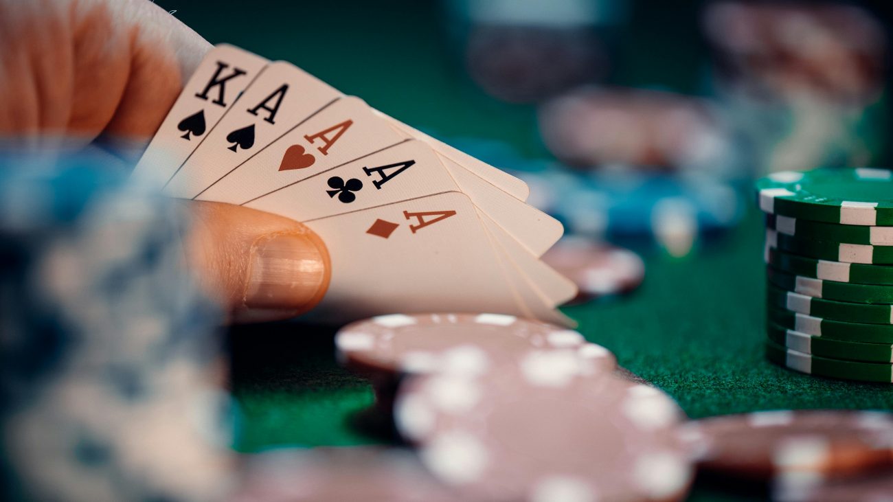 Mesa de jogo de cassino ao vivo com pessoa segurando cartas de baralho. Artigo sobre cassinos que pagam via pix.