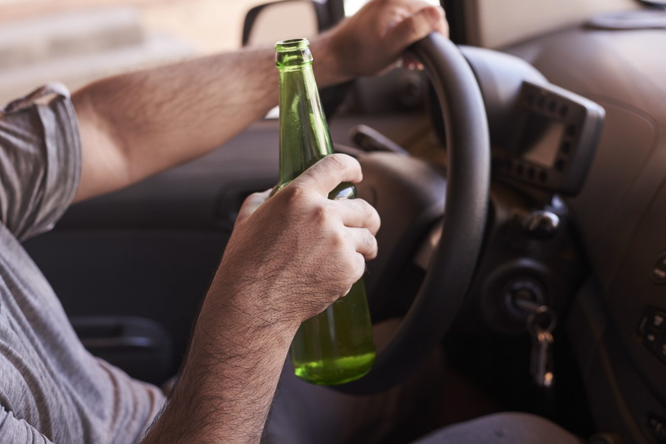 na foto aparece um homem com uma garrafa de cerveja sem álcool dirigindo o carro na foto aparece um homem com uma garrafa de cerveja sem álcool dirigindo o carro
