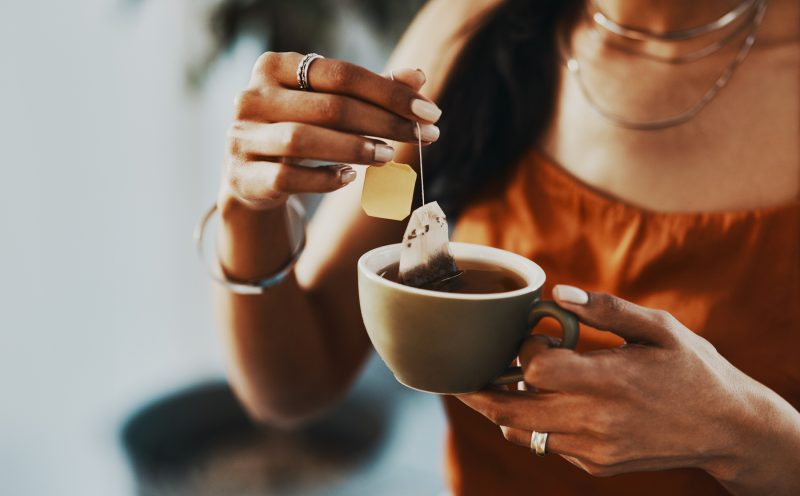 Mulher tomando chá preto para substituir o café