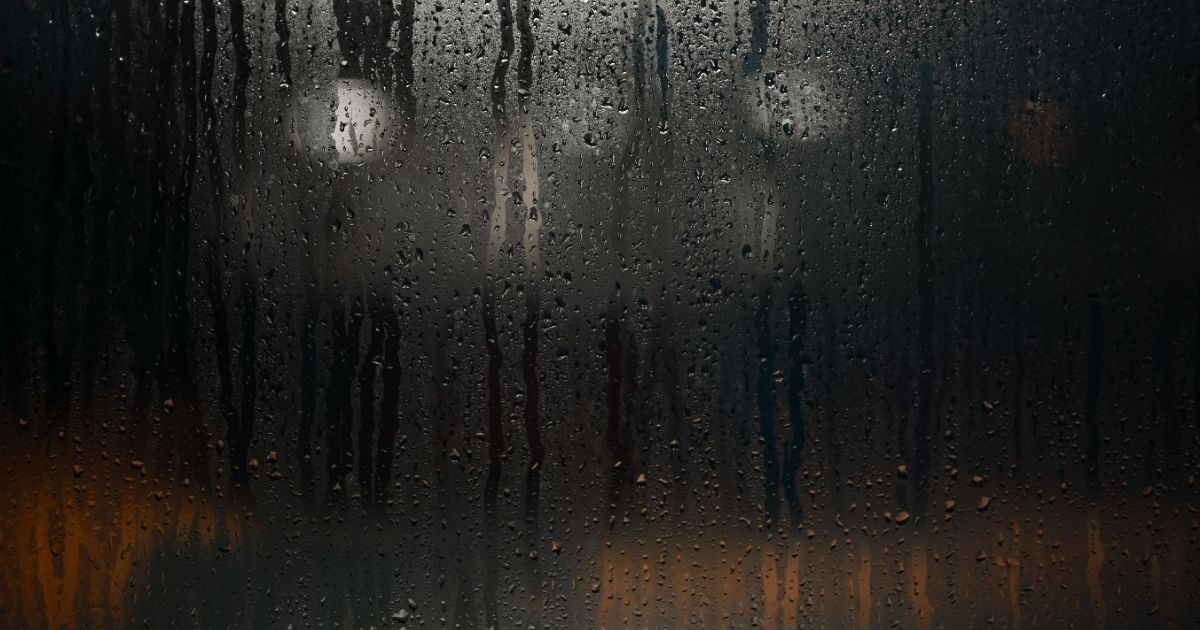 Imagem de um vidro com pingos de chuva, para indicar que a previsão do tempo terá dias chuvosos 