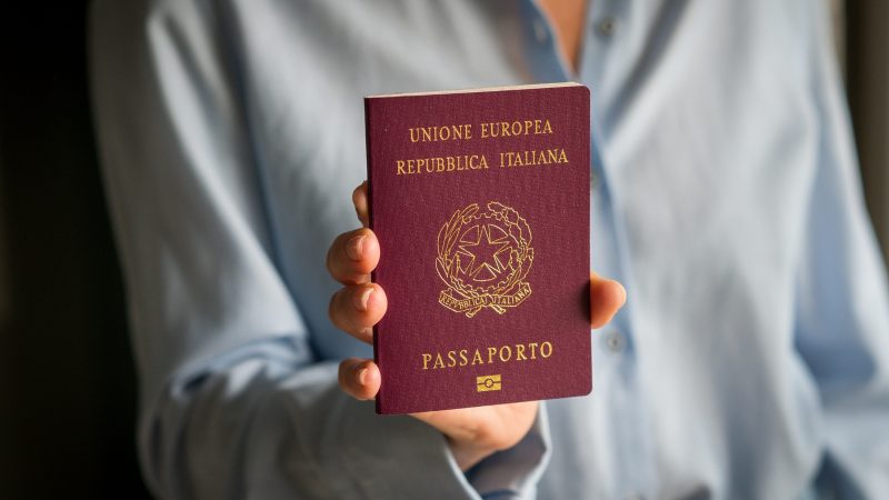 Cidadania italiana Imagem de pessoa segurando passaporte europeu da Ttália para matéria sobre quais sobrenomes que dão direito à cidadania italiana