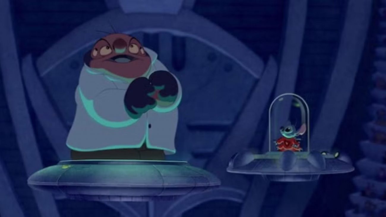 Doutor Jumba Jookib e Stitch Imagem mostra cena do filme Lilo & Stitch onde aparecem Doutor Jumba Jookib e Stitch em um laboratório azul.