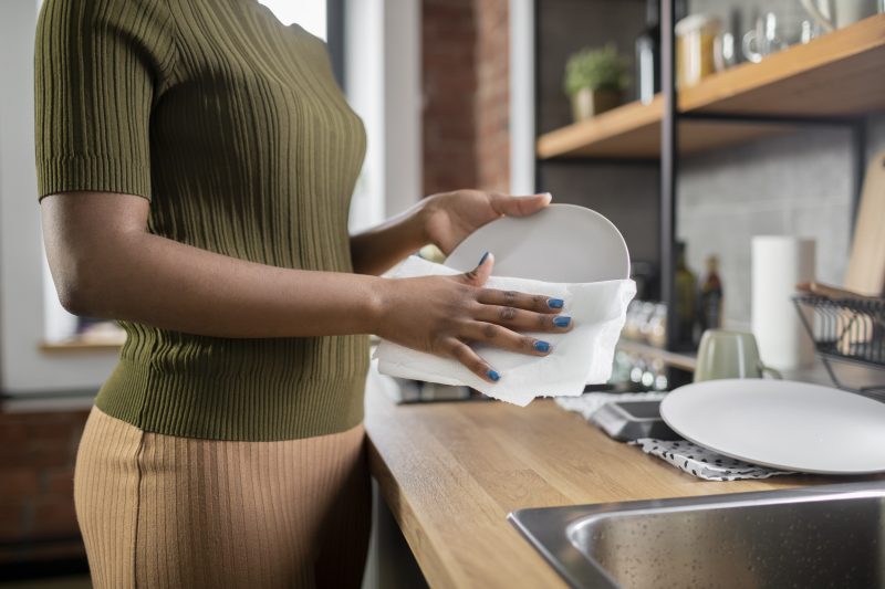 Removendo resíduos dos pratos Pessoa removendo resíduos de alimentos dos pratos